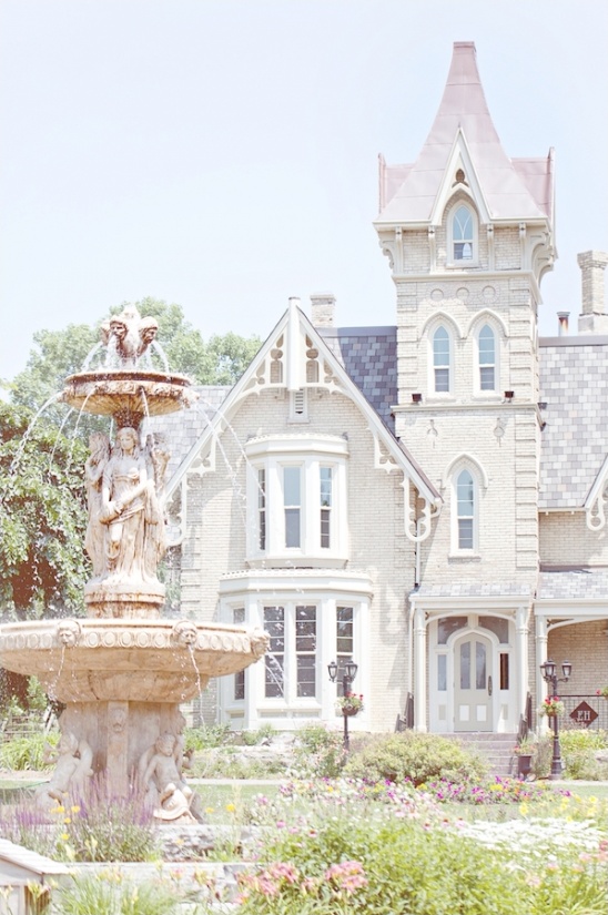 Elegant mansion with a water fountain in a lush garden