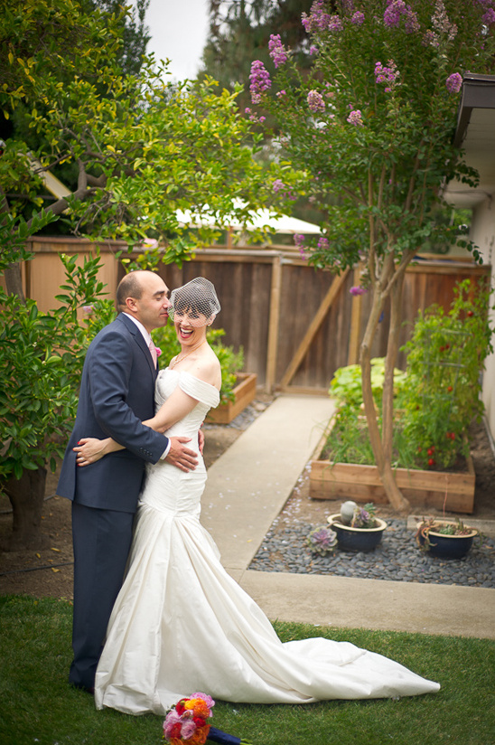 Happy bride and groom embracing in a backyard wedding setting