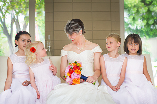 Bride smiles with flower girls at a wedding, joy and happiness