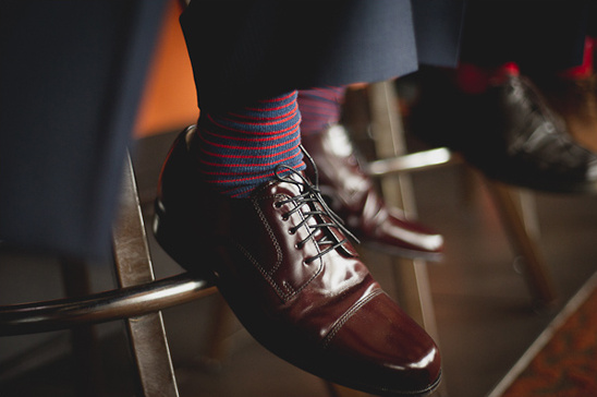 Close up of stylish leather shoes and striped socks on display