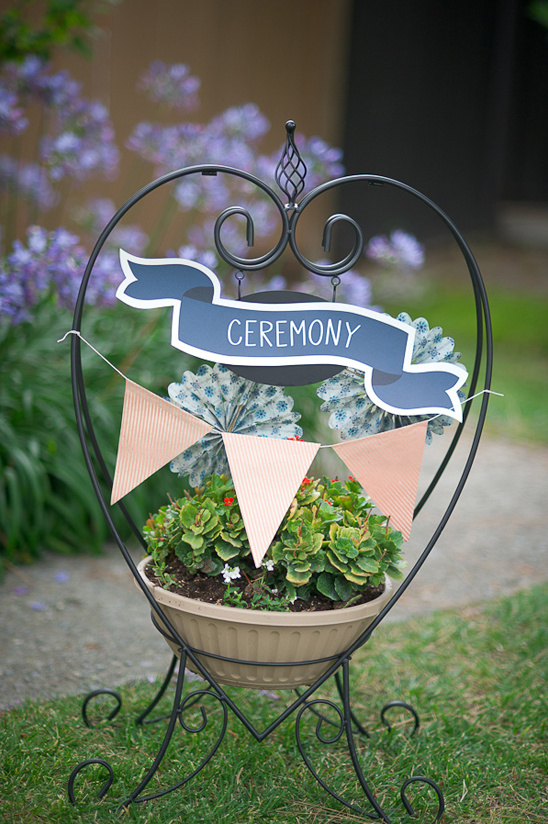 Ceremony sign with flowers in a decorative heart-shaped stand in a garden