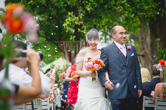 Happy bride and groom walk down the aisle after their wedding