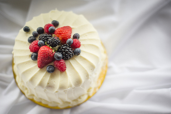 Delicious cake with fresh berries on a white fabric background