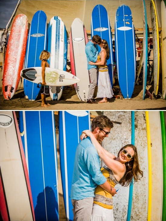 Couple sharing a kiss by colorful surfboards and a young surfer