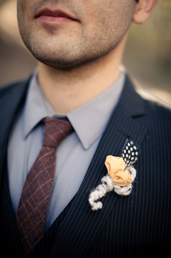 Stylish groom with a flower detail on his lapel wearing a suit