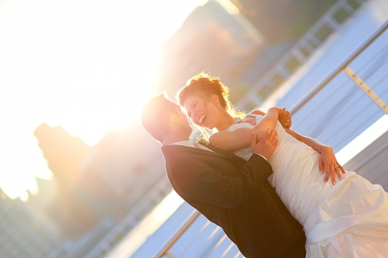 Joyful bride and groom share a loving moment in the sunlight