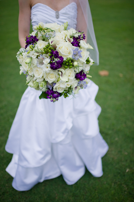 Bride holding a beautiful wedding bouquet of white and purple flowers