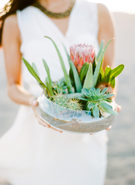 Woman holding a beautiful terrarium with various succulents and plants