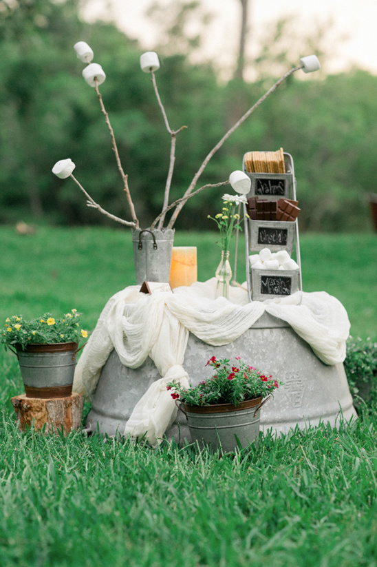 Smores station outdoor with marshallows, chocolate and flowers arrangement