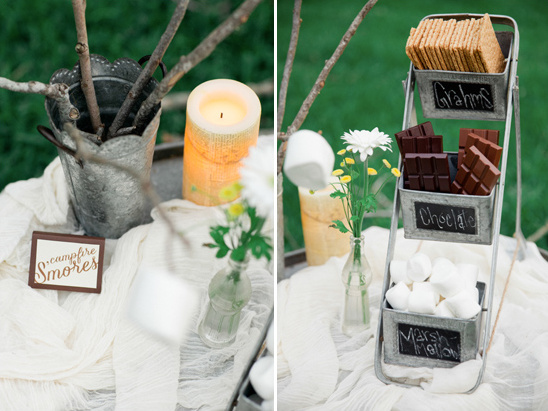 Campfire s'mores ingredients display with candle and sticks