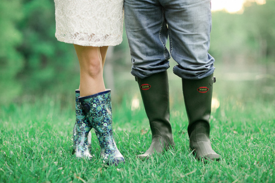 Couple in the field wearing wellington boots standing on the grass