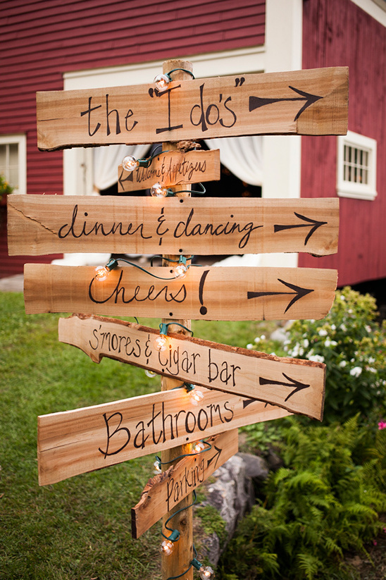 Rustic wooden wedding sign pointing guests to different areas