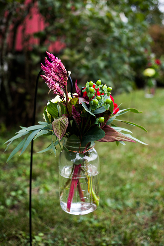 Colorful floral arrangement in a mason jar hanging outdoors