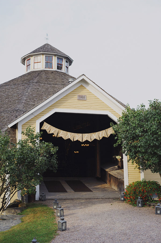 Old yellow barn with a banner, perfect for a wedding venue