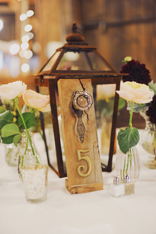 Rustic wedding table number five with lantern and flowers