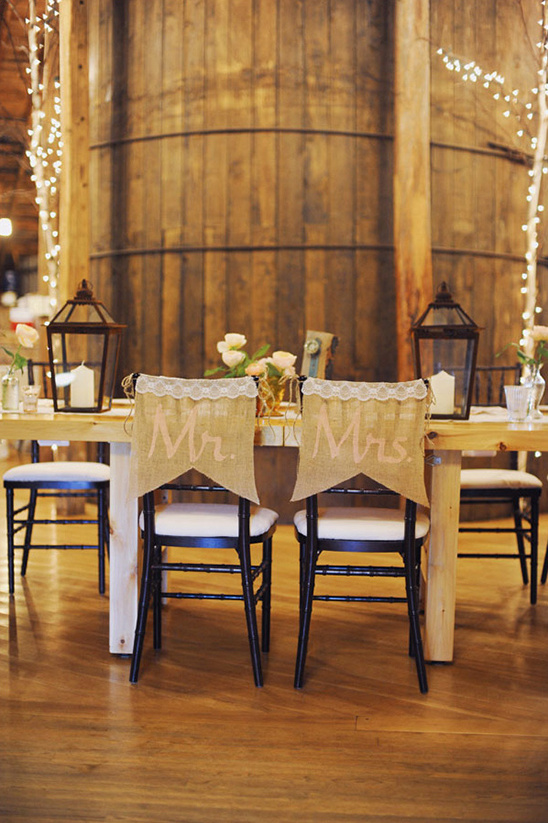 Rustic wedding reception table setting with Mr and Mrs chair signs