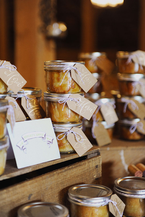 Jarred desserts with Merci tags on a wooden display