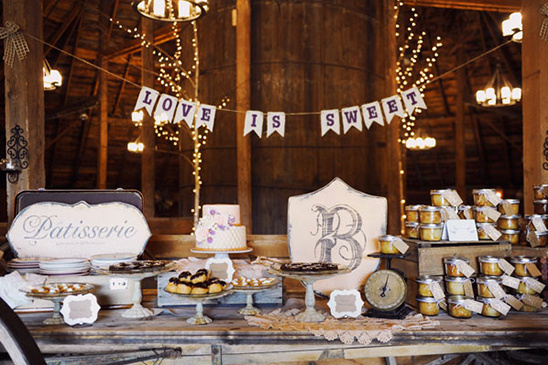 Rustic dessert table with a Love is Sweet banner for a wedding