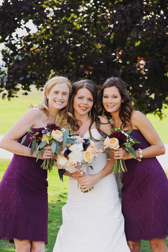 Bride with bridesmaids smiling on wedding day with flowers