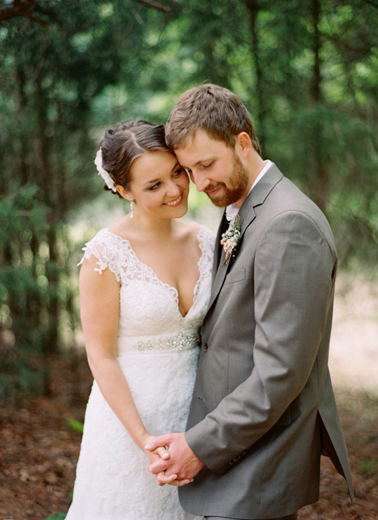 Affectionate bride and groom embrace in a forest setting on their wedding day
