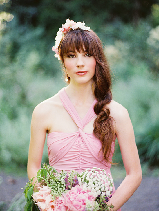 Beautiful woman in pink dress with flower crown and bouquet