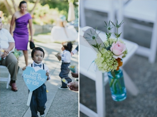 A charming young boy carries a Here Comes the Bride sign at a wedding