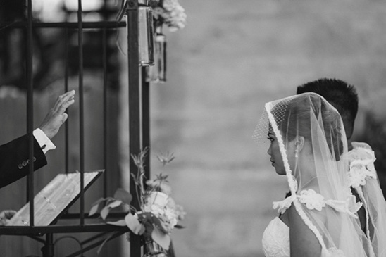 Bride and groom at a wedding ceremony with officiant's hand raised