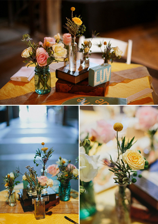 Floral wedding centerpieces with roses, books, and a LUV sign