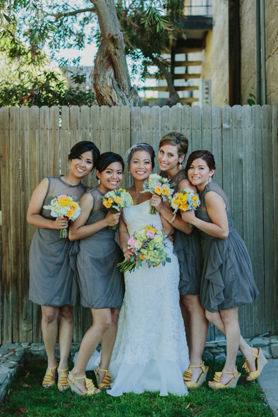 Bride with bridesmaids in gray dresses holding flowers