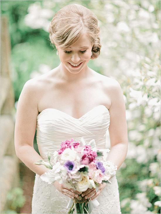 Smiling bride holding a beautiful bouquet of flowers on her wedding day