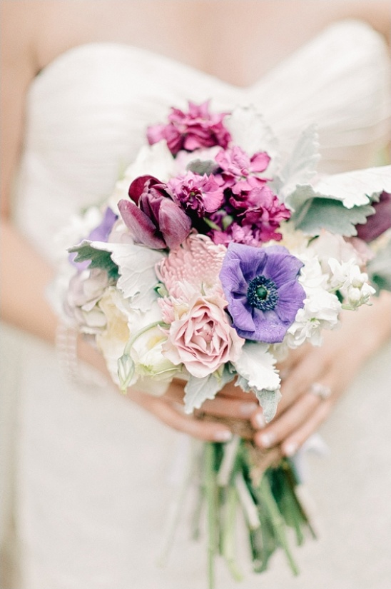 Bride holding a beautiful bouquet of mixed purple and pink flowers
