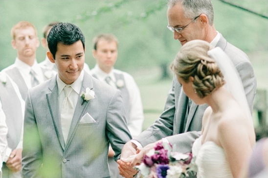 Smiling groom at wedding ceremony with bride and officiant