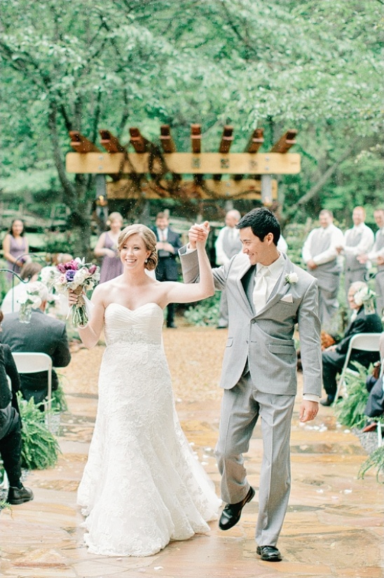 Newlyweds walking happily after their outdoor wedding ceremony