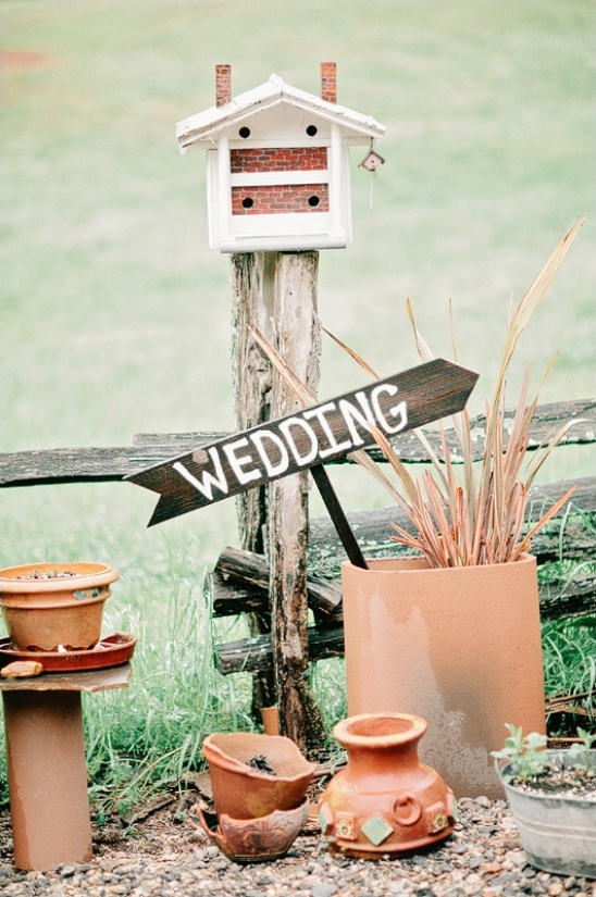 Rustic wedding decor with birdhouse and wedding sign
