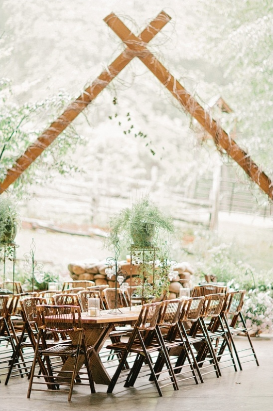 Rustic wedding reception setup with wooden tables and chairs