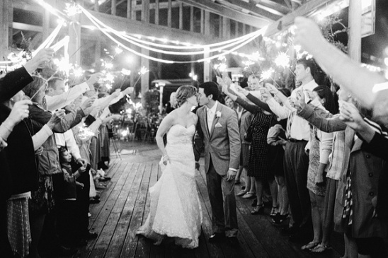 Newlyweds kiss beneath sparklers at a romantic wedding celebration