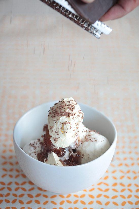 Grated chocolate sprinkles on ice cream in a white bowl, dessert time