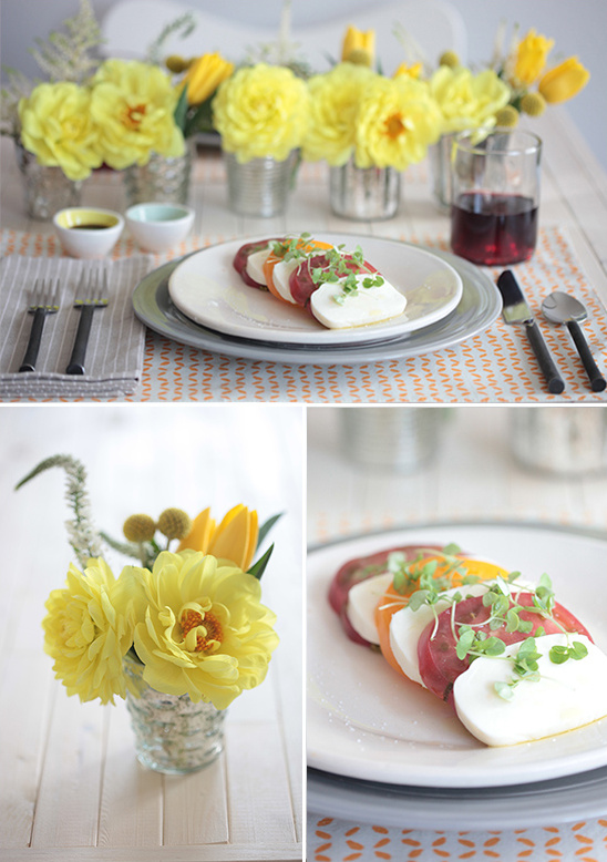 Elegant dinner table setting with caprese salad and yellow flowers