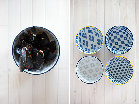 Steamed mussels with patterned bowls on a white wooden surface