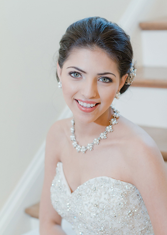 Beautiful bride smiling, wearing pearl jewelry and a wedding dress