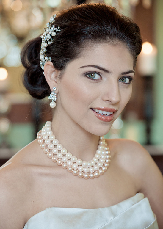 Bride in white gown with pearl necklace and hair accessory