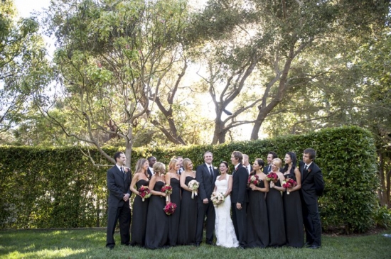 Wedding party in black attire posing outdoors