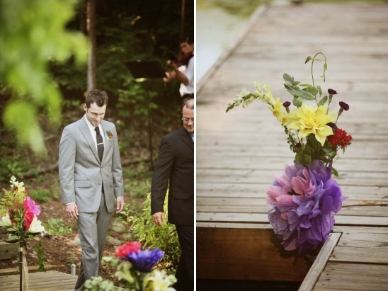 Groom walking down aisle toward colorful wedding flowers