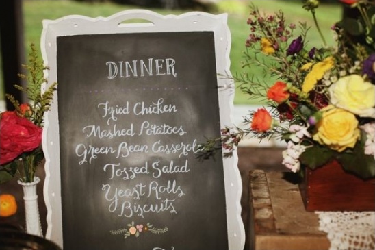 Dinner menu on chalkboard with fried chicken and rolls