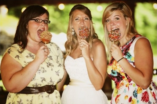 Three women enjoy caramel apples at wedding party