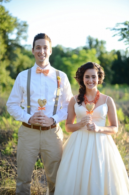 Happy couple holding heart-shaped treats at wedding