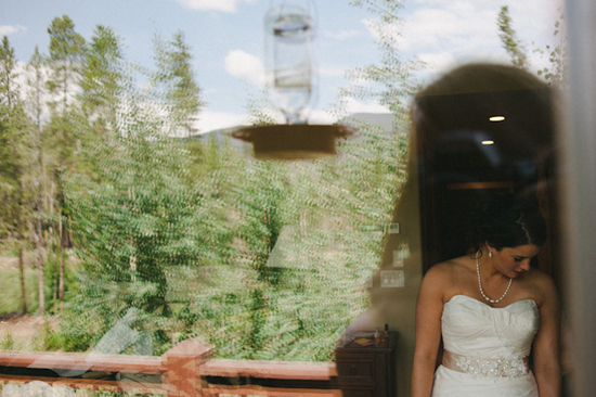 Bride in wedding dress reflected in window