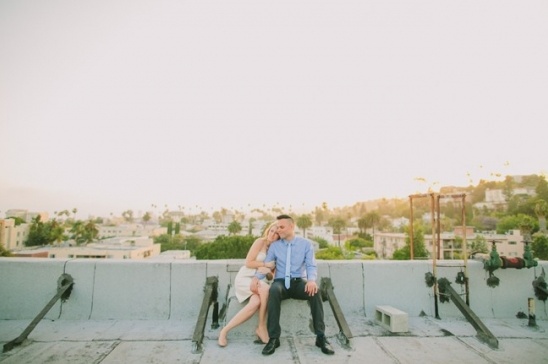 Couple sits on rooftop overlooking city