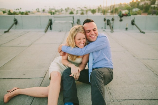 Happy couple hugging on a rooftop at sunset