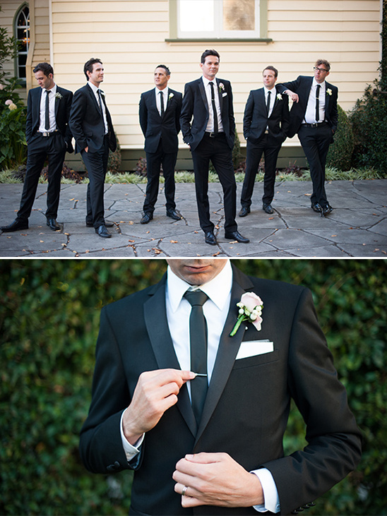 Groomsmen in black tuxedos pose for wedding photo